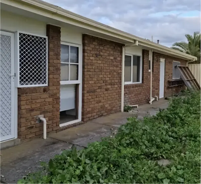 Before: back of a brick home