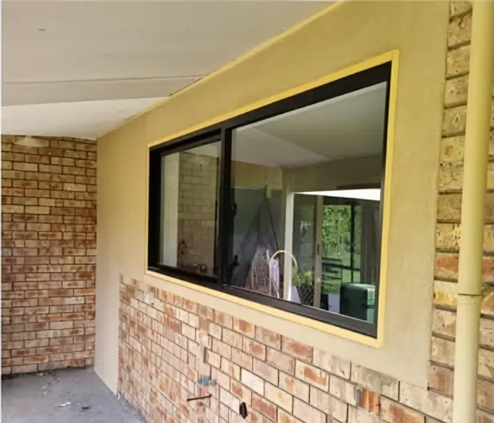 Rendered: the wall around the window above face brick, masking still on the frame