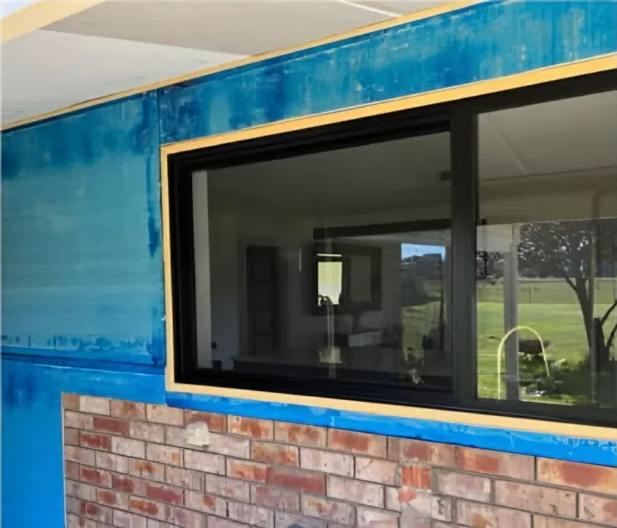 During: the wall above the brickwork part way through, window masked